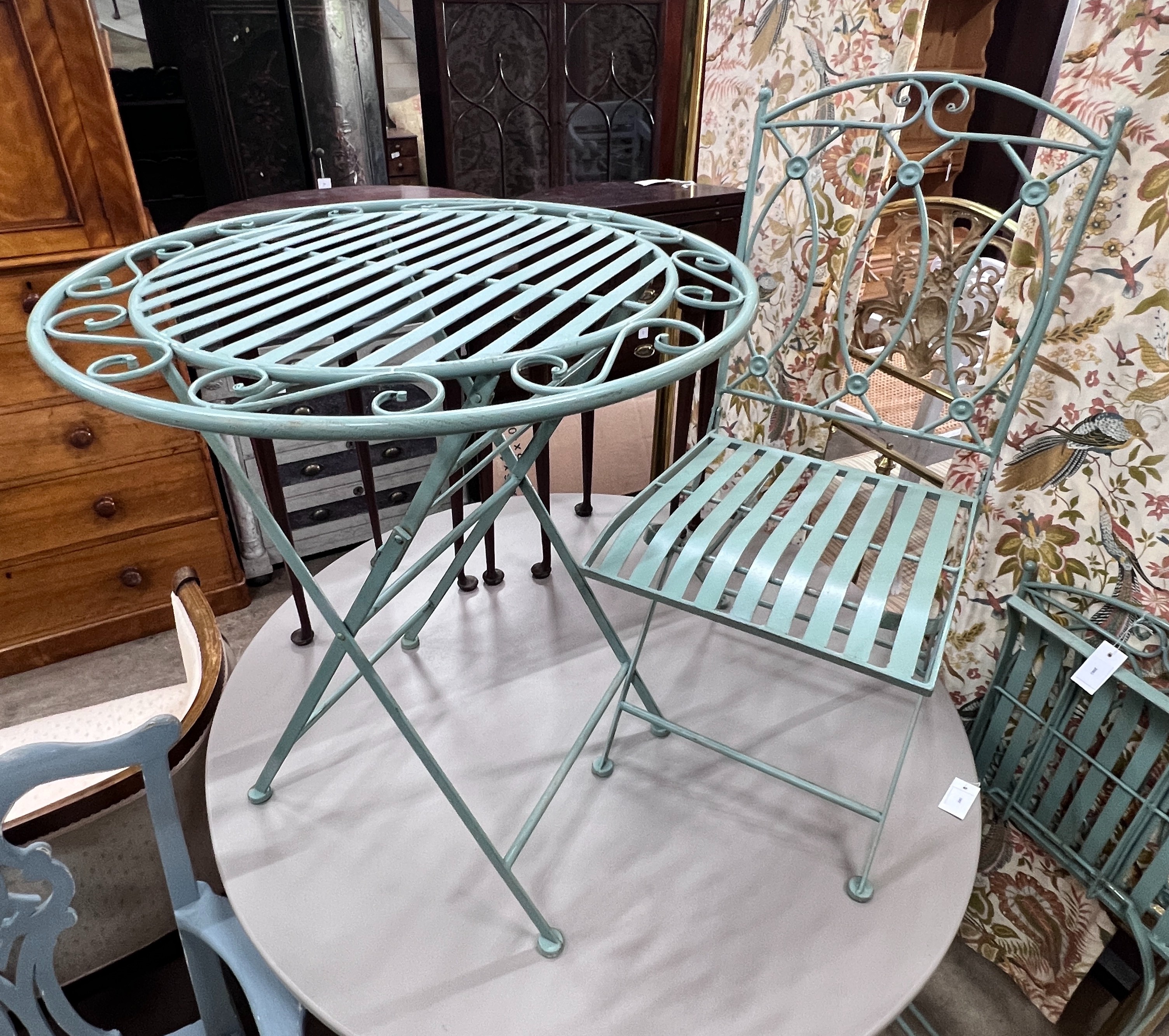 A circular painted folding garden table, diameter 69cm, height 76cm and two folding chairs